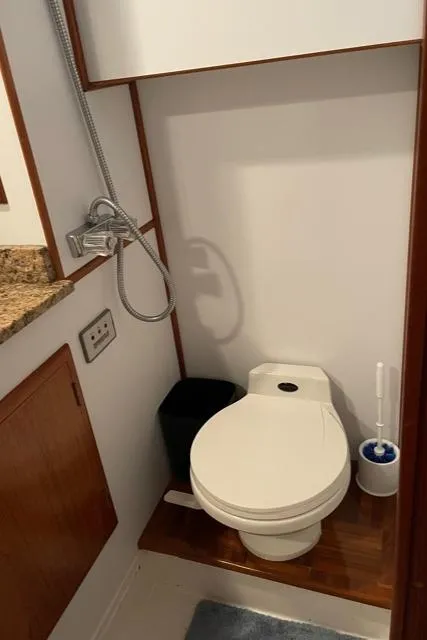 Slide: The Image of 1994 DeFever Double Cabin bathroom with toilet, showerhead, and wooden accents. - 33