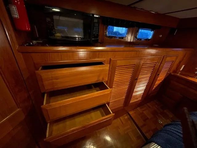 Slide: The Image of 1994 DeFever Double Cabin interior with wooden cabinets, open drawers, and a microwave. - 37