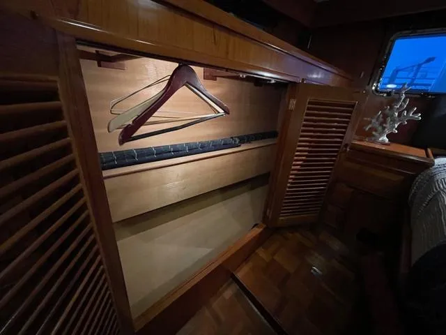 Slide: The Image of 1994 DeFever Double Cabin interior with wooden closet and hangers, showcasing elegant marine design. - 38