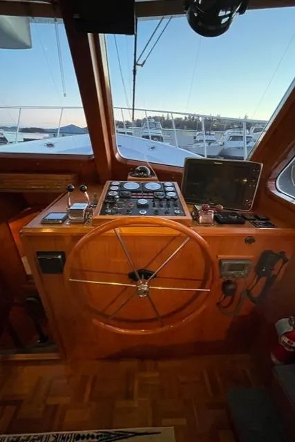 Slide: The Image of 1994 DeFever Double Cabin helm with wooden wheel, control panel, and navigation equipment. - 41