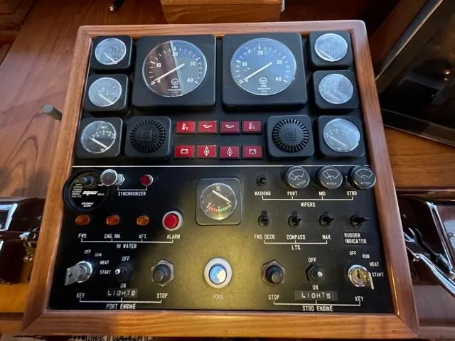 Slide: The Image of 1994 DeFever Double Cabin control panel with gauges and switches on a wooden dashboard. - 42