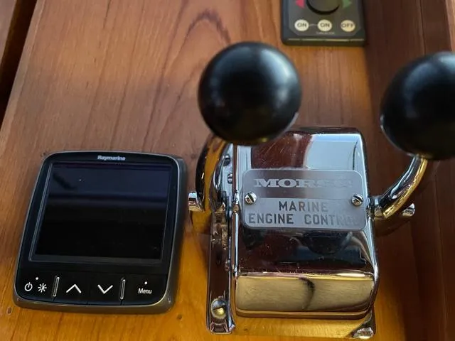 Slide: The Image of 1994 DeFever Double Cabin marine engine controls and Raymarine display on wooden panel. - 44