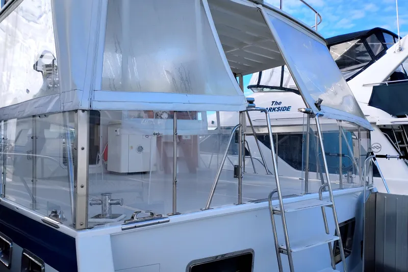 Slide: The Image of 1994 DeFever Double Cabin yacht with enclosed deck and ladder, docked at marina. - 5