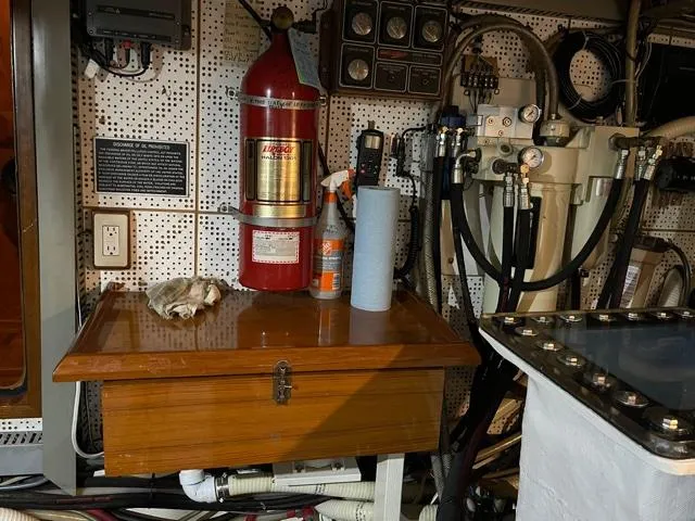 Slide: The Image of Engine room of a 1994 DeFever Double Cabin with fire extinguisher and control panels. - 58
