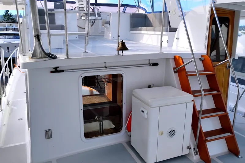 Slide: The Image of 1994 DeFever Double Cabin yacht with wooden stairs and outdoor seating area. - 7