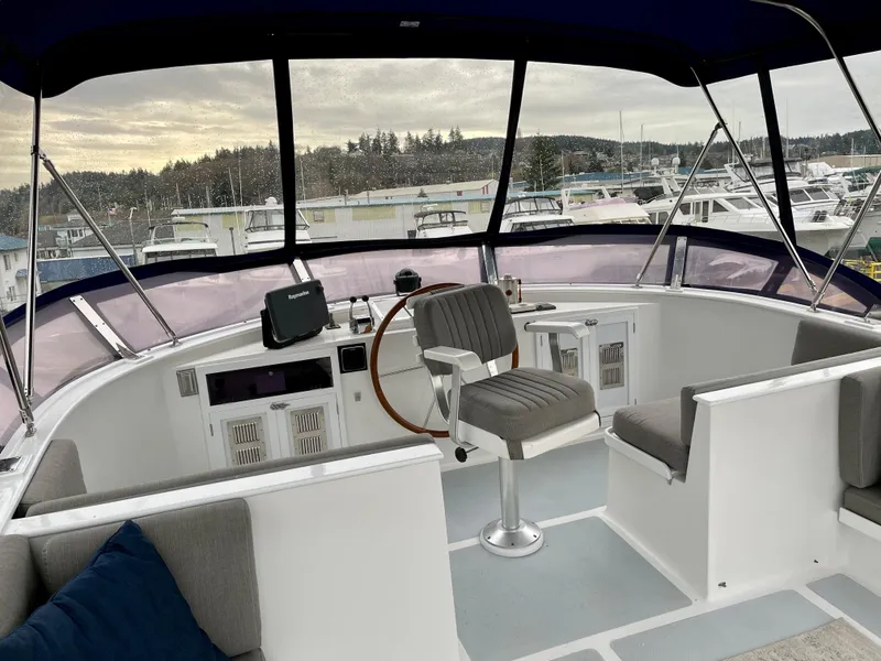 Slide: The Image of 1994 DeFever Double Cabin yacht helm with seating, overlooking marina and trees. - 8