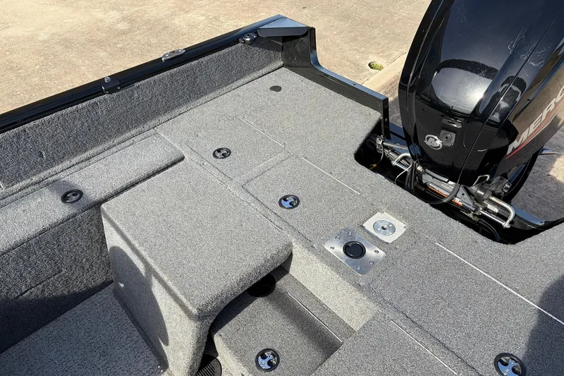 Slide: The Image of 2022 Tracker Pro Guide V-175 Combo boat interior with gray carpet and engine view. - 36