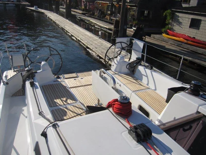 Slide: The Image of 2024 Jeanneau 380 sailboat docked, featuring dual steering wheels and teak deck. - 32