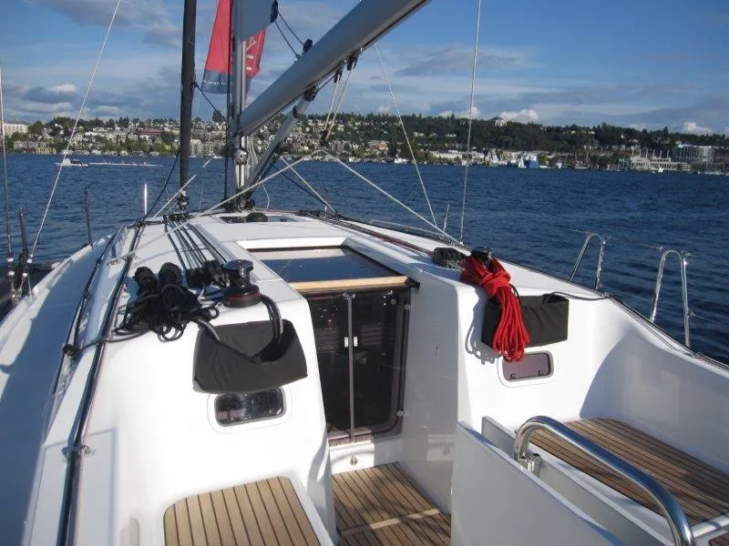 Slide: The Image of 2024 Jeanneau 380 sailboat deck with scenic waterfront view. - 33