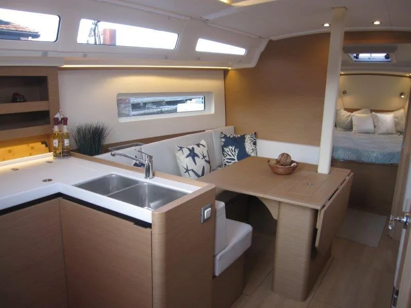 Slide: The Image of Modern interior of 2024 Jeanneau 380 sailboat with kitchen, dining area, and cozy sleeping quarters. - 6