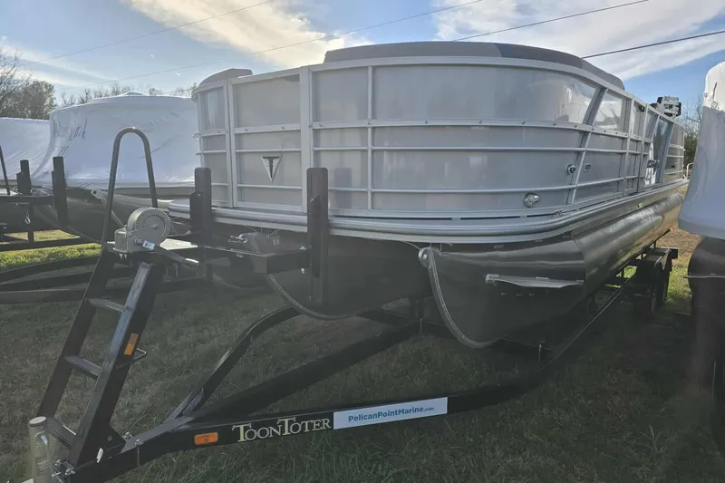 Slide: The Image of 2026 Trifecta 24ULCS3 pontoon boat on trailer under clear sky. - 1