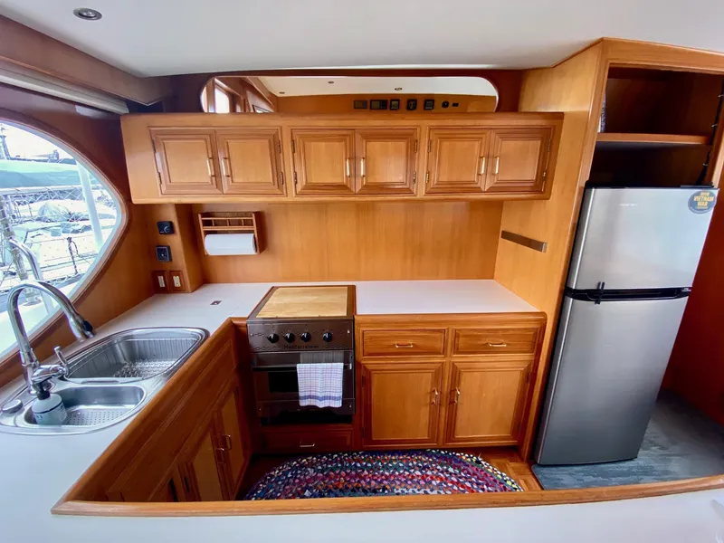Slide: The Image of 1999 Ocean Alexander 510 Pilothouse kitchen interior with wood cabinetry. - 44