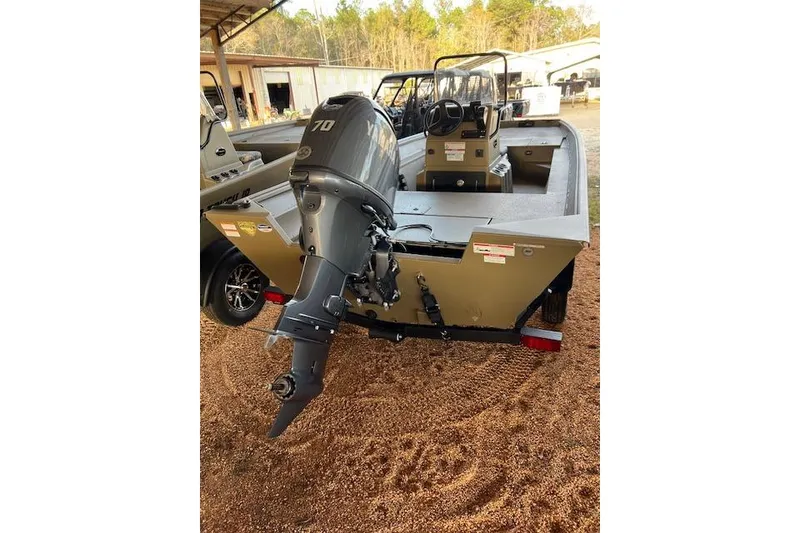 Slide: The Image of 2026 G3 Gator Tough 17 CC boat with outboard motor, parked on gravel. - 6