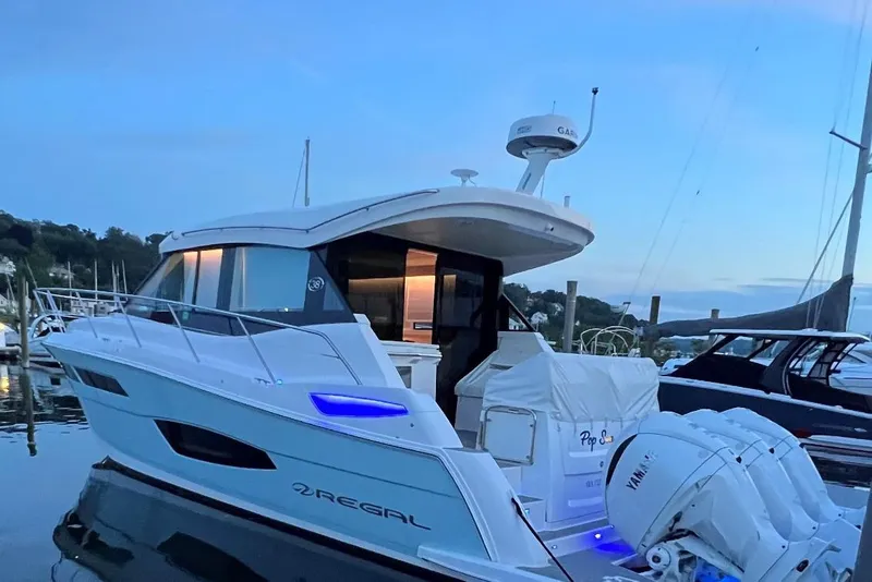 Slide: The Image of 2022 Regal 38 XO yacht docked at sunset with Yamaha engines. - 3