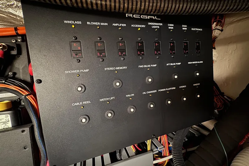 Slide: The Image of Electrical control panel of a 2022 Regal 38 XO boat with labeled switches and wiring. - 34