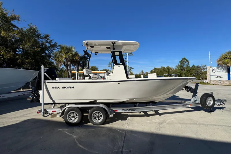 Slide: The Image of 2026 Sea Born LX231 Center Console boat on trailer, parked outdoors under clear blue sky. - 10