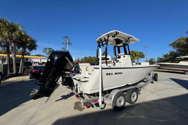 Slide: The Image of 2026 Sea Born LX231 Center Console boat on trailer, parked outdoors under clear blue sky. - 12