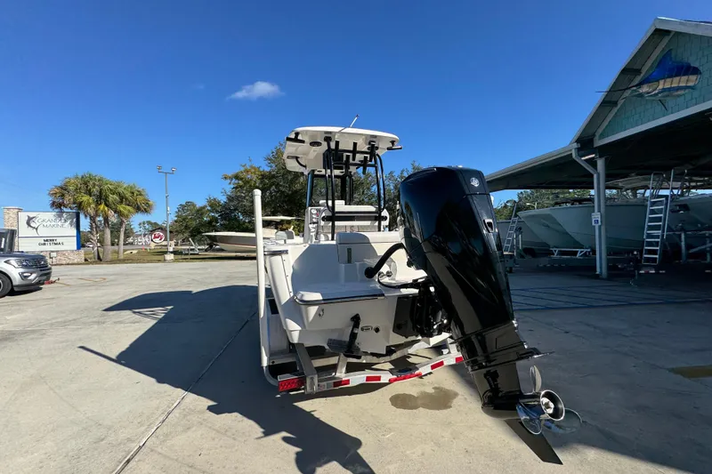 Slide: The Image of 2026 Sea Born LX231 Center Console boat with outboard motor in a marina setting. - 15