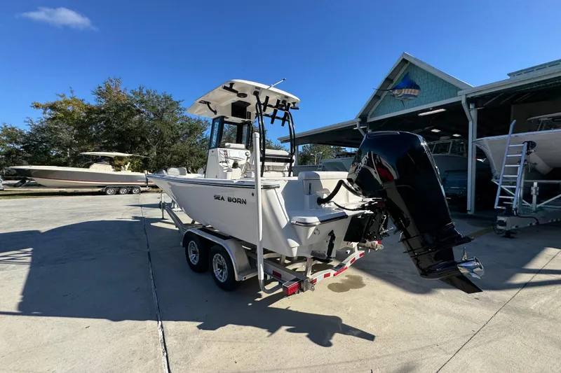 Slide: The Image of 2026 Sea Born LX231 Center Console boat on trailer, parked outdoors under clear blue sky. - 16