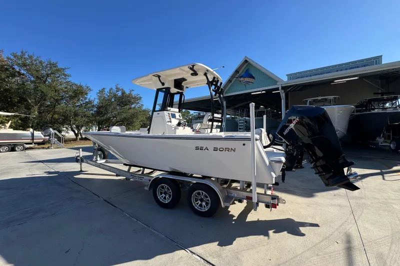Slide: The Image of 2026 Sea Born LX231 Center Console boat on trailer, parked outdoors under clear blue sky. - 17