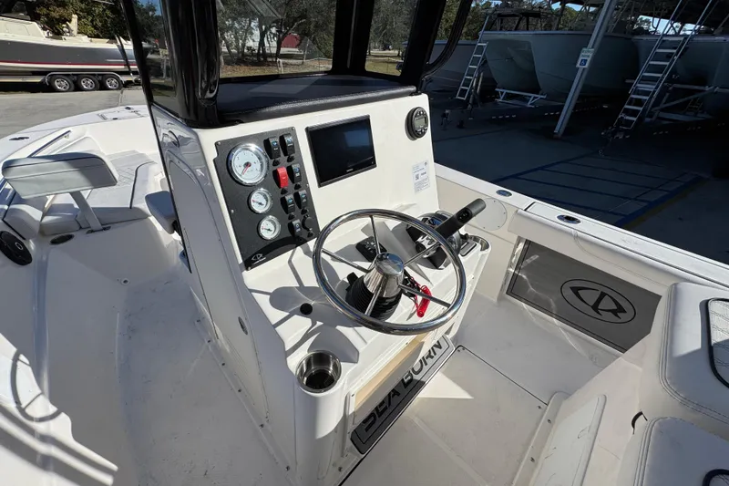 Slide: The Image of 2026 Sea Born LX231 Center Console boat interior with steering wheel and control panel. - 29