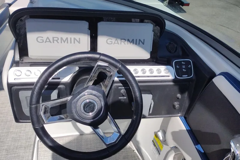 Slide: The Image of Steering wheel and dashboard of 2026 Crownline 260 XSS boat with Garmin displays. - 11