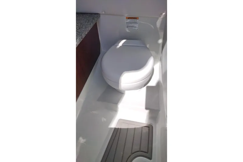 Slide: The Image of 2026 Crownline 260 XSS boat interior with compact marine toilet. - 19