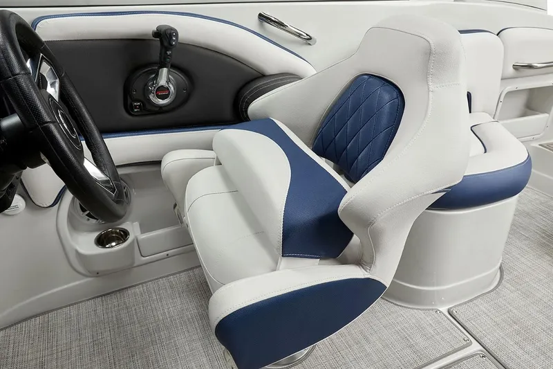 Slide: The Image of Captain's seat and controls of 2026 Crownline 260 XSS boat, featuring blue and white upholstery. - 3