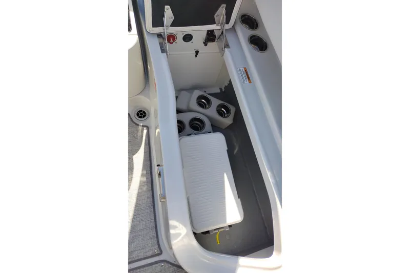 Slide: The Image of Storage compartment in 2026 Crownline 260 XSS boat, featuring cup holders and a cooler. - 33