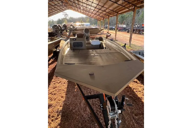 Slide: The Image of 2026 G3 Gator Tough 17 SC boat under a metal canopy, parked on gravel. - 5