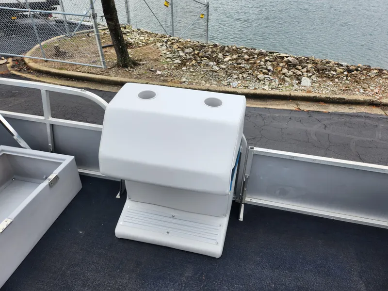 Slide: The Image of 1991 Grumman Fish N Fun boat interior with console, docked by rocky shoreline. - 12