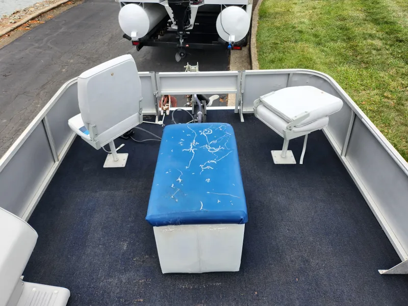 Slide: The Image of 1991 Grumman Fish N Fun boat interior with blue seating and white chairs. - 18