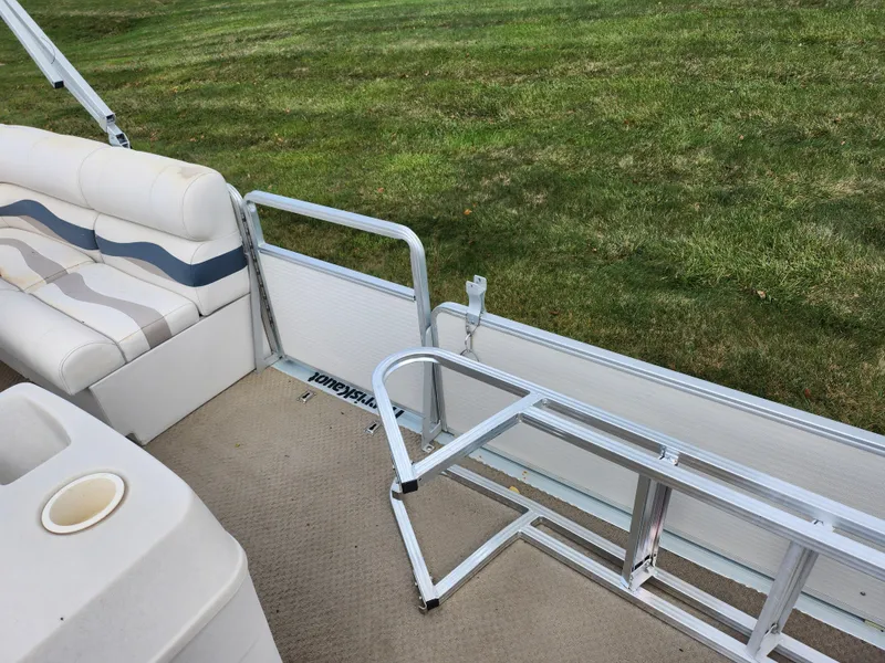 Slide: The Image of 2002 Harris FloteBote 220 Fisherman interior with seating and railing on grassy background. - 12