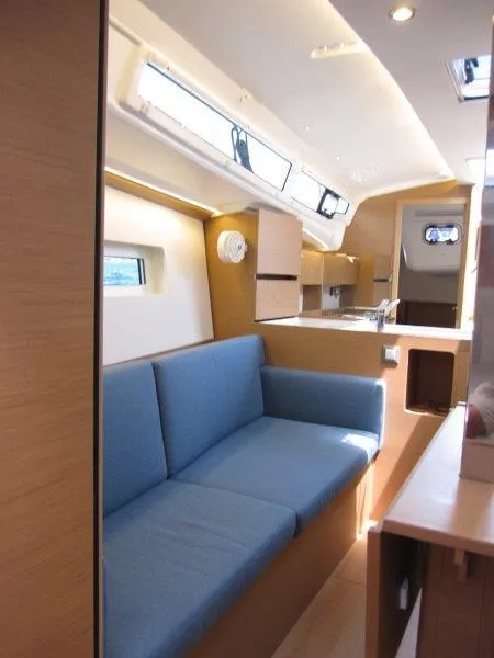 Slide: The Image of 2025 Jeanneau Sun Odyssey 350 interior with blue sofa and modern kitchen. - 8