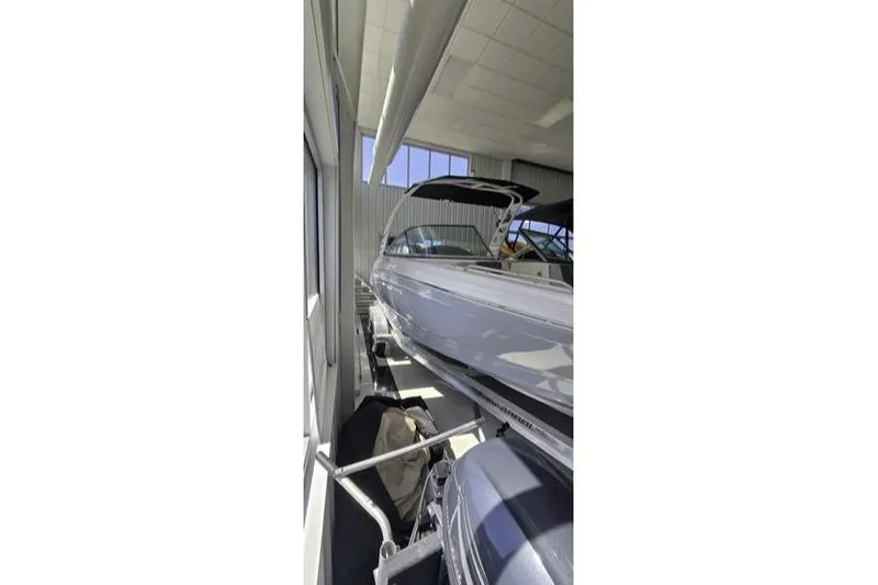 Slide: The Image of 2025 Chaparral 23 SSi OB boat in indoor storage, side view. - 2