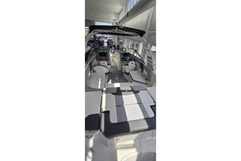 Slide: The Image of 2025 Chaparral 23 SSi OB boat interior with seating and helm in showroom. - 6
