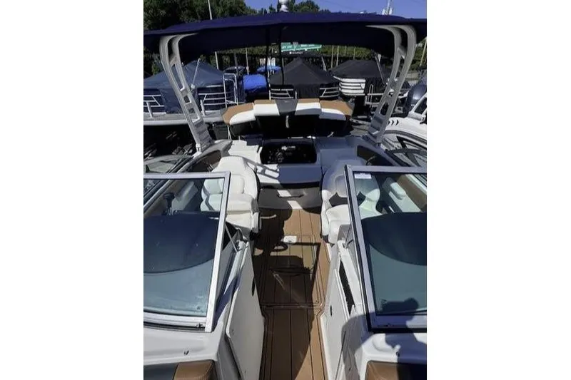 Slide: The Image of 2025 Chaparral 21 SSi boat interior with seating and canopy, docked outdoors. - 3