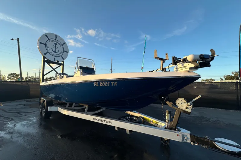 The Image of 2014 Skeeter SX2250 boat on trailer under blue sky at dealership. - 0
