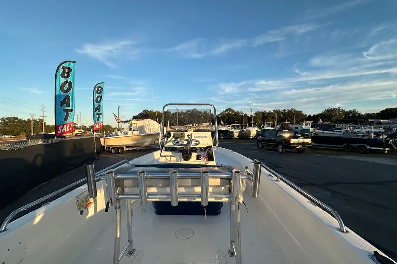 Slide: The Image of 2014 Skeeter SX2250 boat with trolling motor, displayed outdoors under a partly cloudy sky. - 12