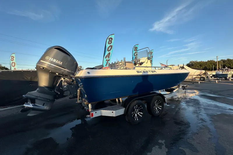 Slide: The Image of 2014 Skeeter SX2250 boat with Yamaha outboard motor on trailer, under blue sky. - 2