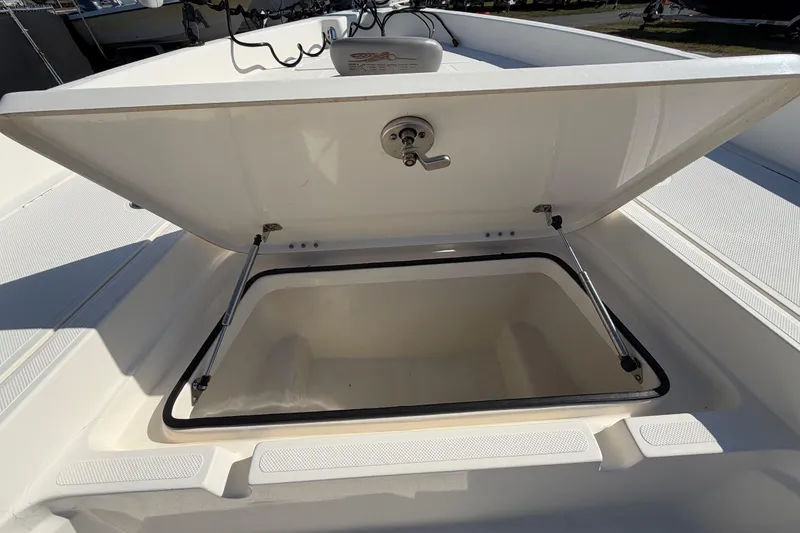 Slide: The Image of 2014 Skeeter SX2250 boat storage compartment, open and empty, with visible drainage holes. - 35