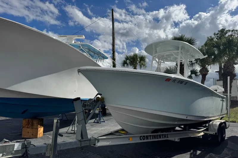 The Image of 2020 Sportsman Heritage 231 Center Console boat on trailer under a cloudy sky. - 0