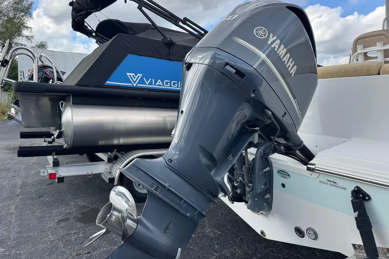 Slide: The Image of 2020 Sportsman Heritage 231 Center Console with Yamaha outboard motor, parked beside a Viaggio pontoon. - 50