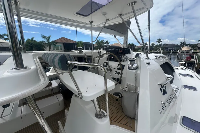 Slide: The Image of 2016 Leopard 44 catamaran cockpit with steering wheel and controls, docked in a marina. - 51