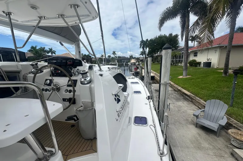 Slide: The Image of 2016 Leopard 44 yacht docked by a canal, featuring a sleek deck and steering wheel. - 52