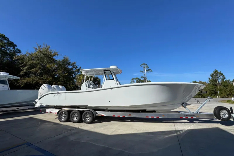 Slide: The Image of 2026 Yellowfin 36 Offshore boat on trailer, parked outdoors under clear blue sky. - 11
