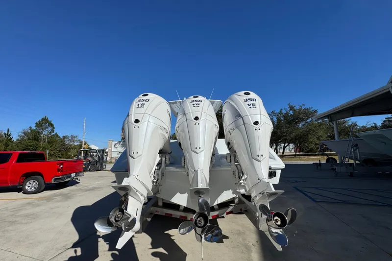 Slide: The Image of 2026 Yellowfin 36 Offshore boat with triple 350 V6 outboard engines, parked outdoors. - 16