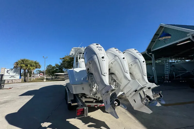 Slide: The Image of 2026 Yellowfin 36 Offshore boat with triple outboard engines in a sunny marina. - 17