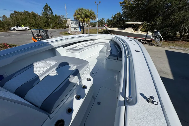 Slide: The Image of 2026 Yellowfin 36 Offshore boat interior with seating and storage, parked outdoors. - 20