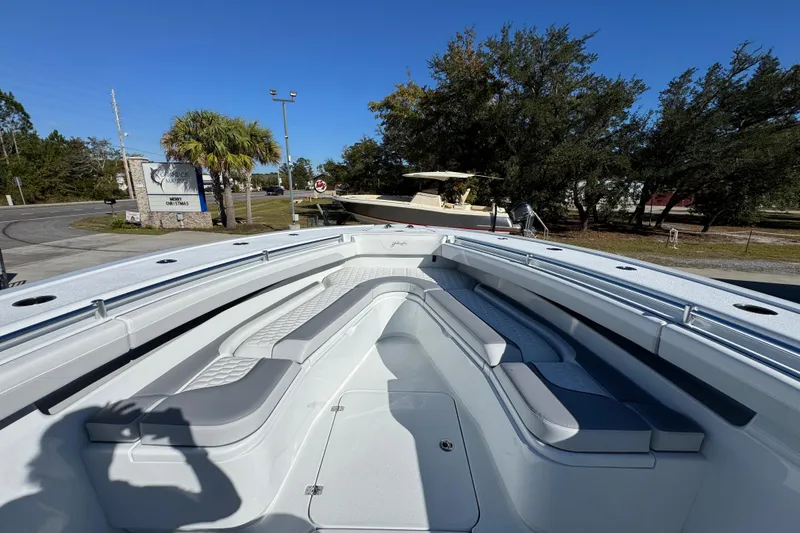 Slide: The Image of 2026 Yellowfin 36 Offshore boat with spacious seating, parked outdoors under clear blue sky. - 21